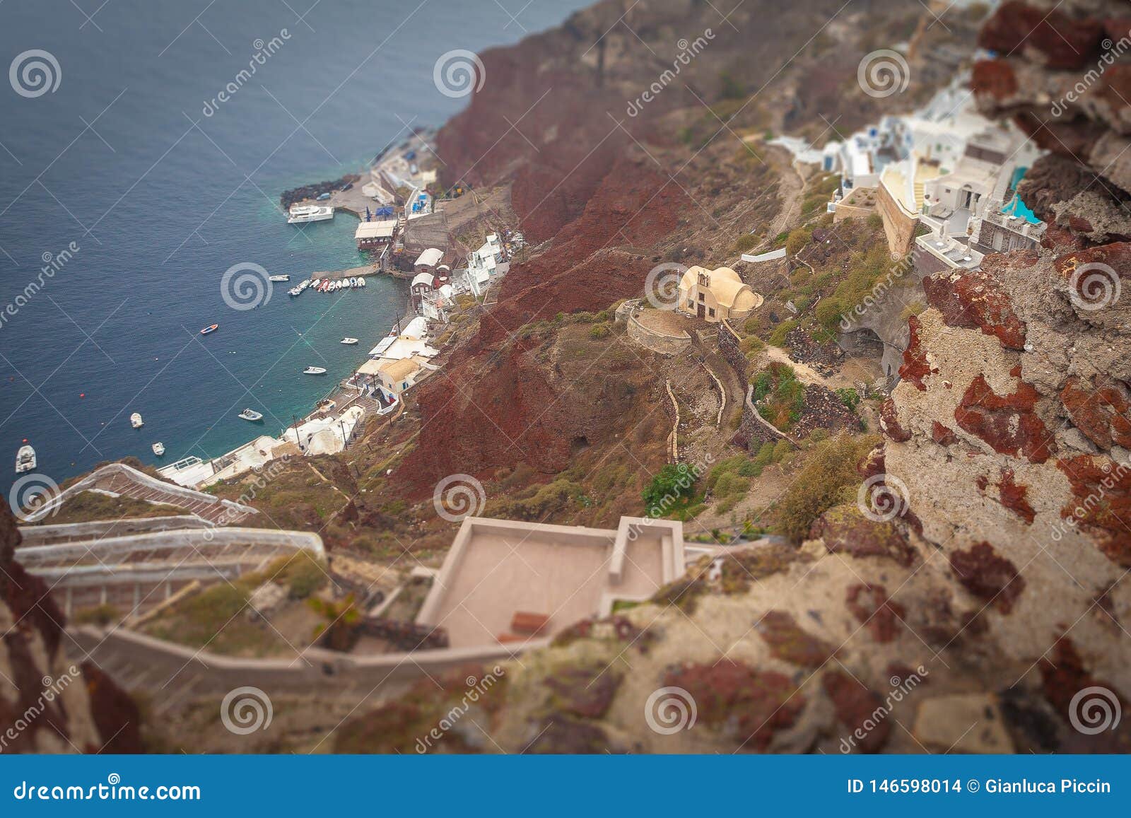 tilt shift effect of oia ammoudi bay red cliffs on a rainy day