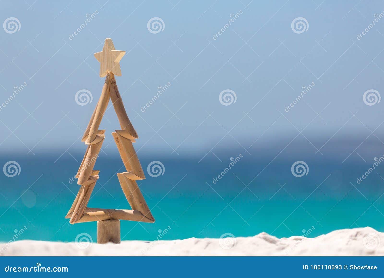 timber christmas tree in sand on the beach