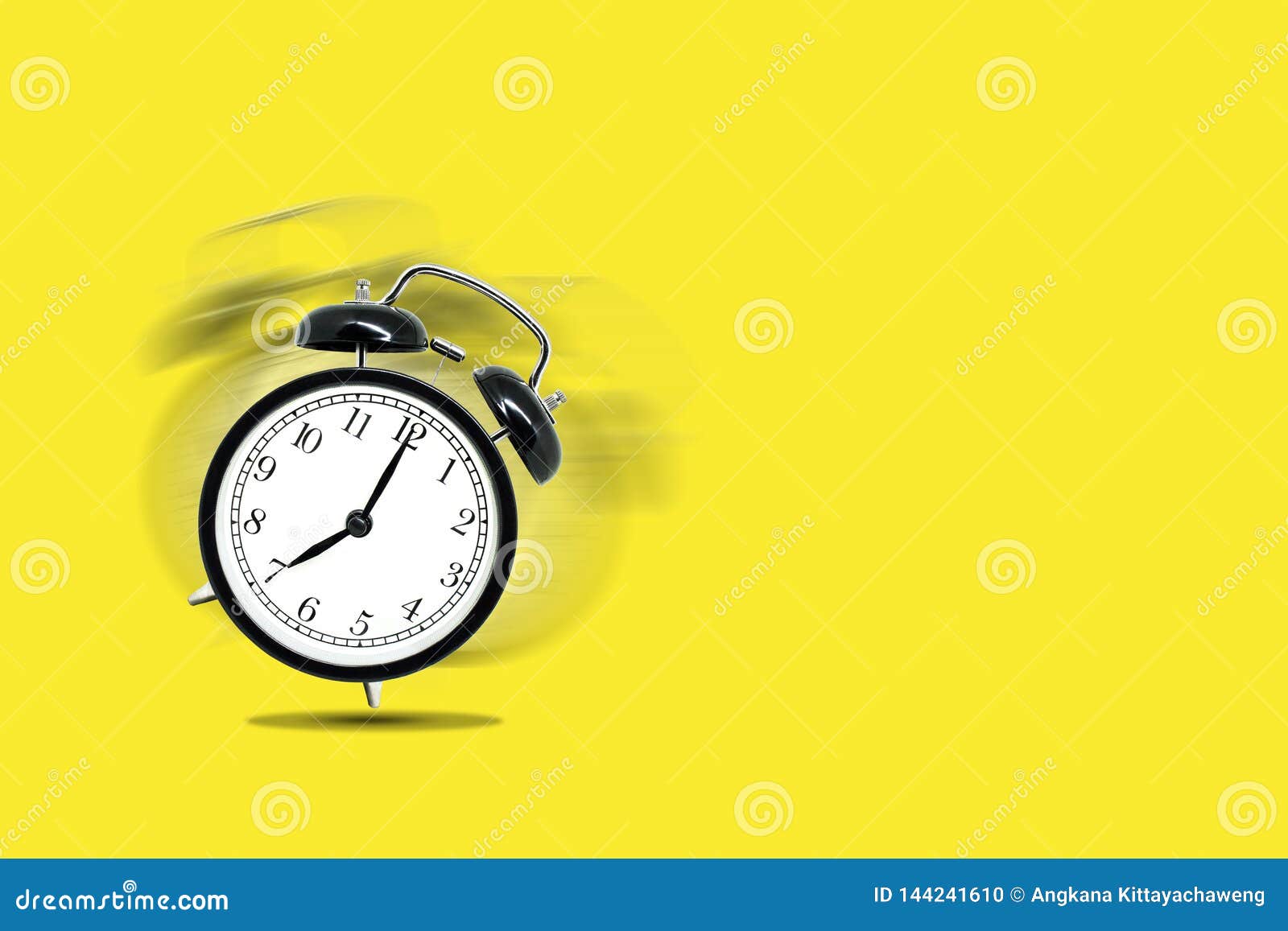 retro black alarm clock alerting at seven o`clock on yellow background.