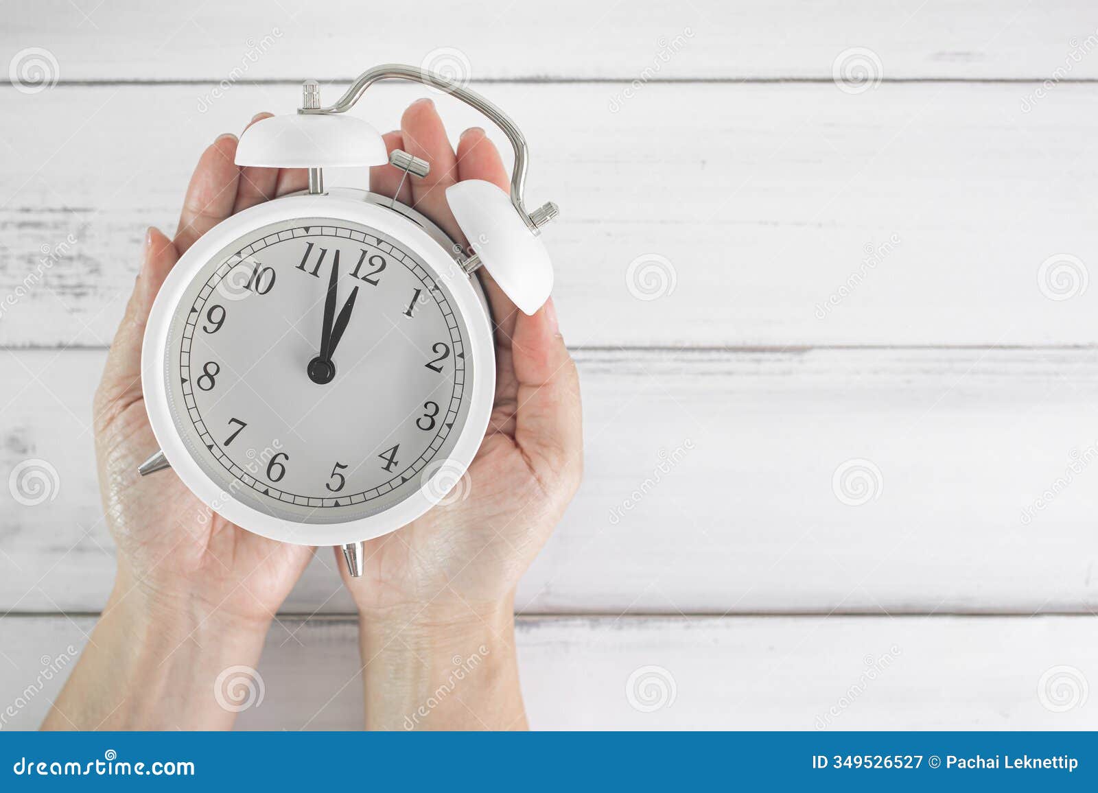 time in your hands: holding a white alarm clock as a  of punctuality and time management