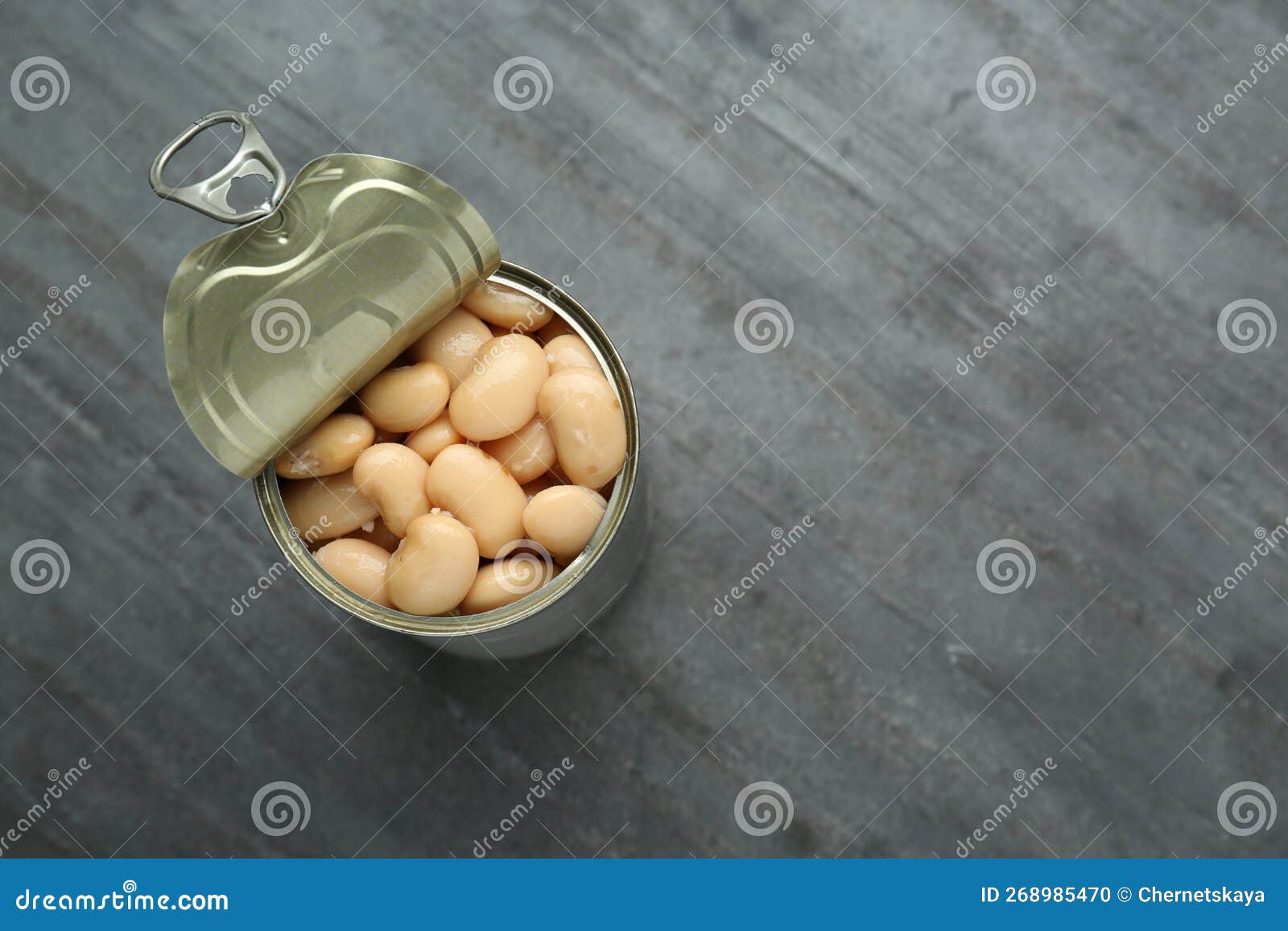 Tin Can of Canned White Kidney Beans on Grey Table, Top View. Space for