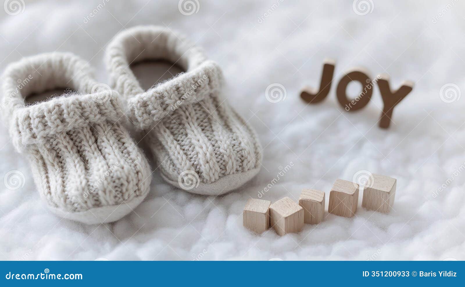 tiny baby booties on soft carpet with play cubes reading joy highlighting innocence