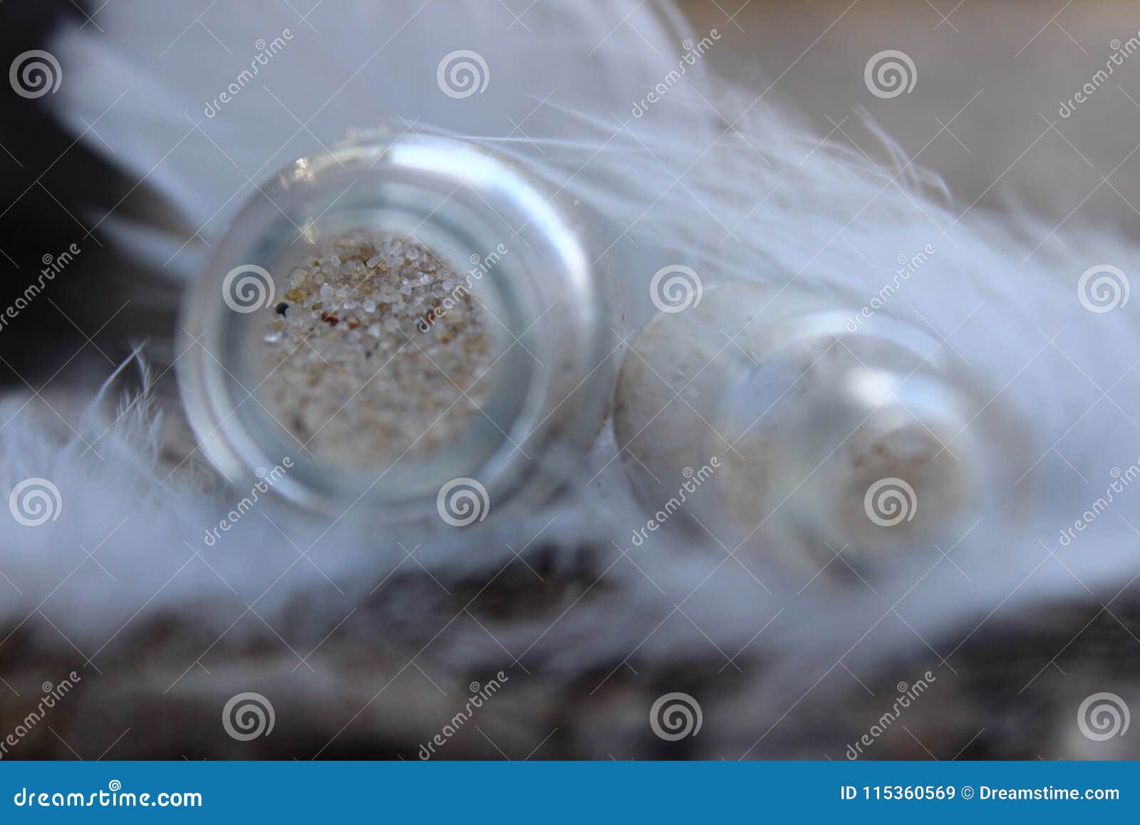 tiny bottles of sand covered with soft feathers of white birds