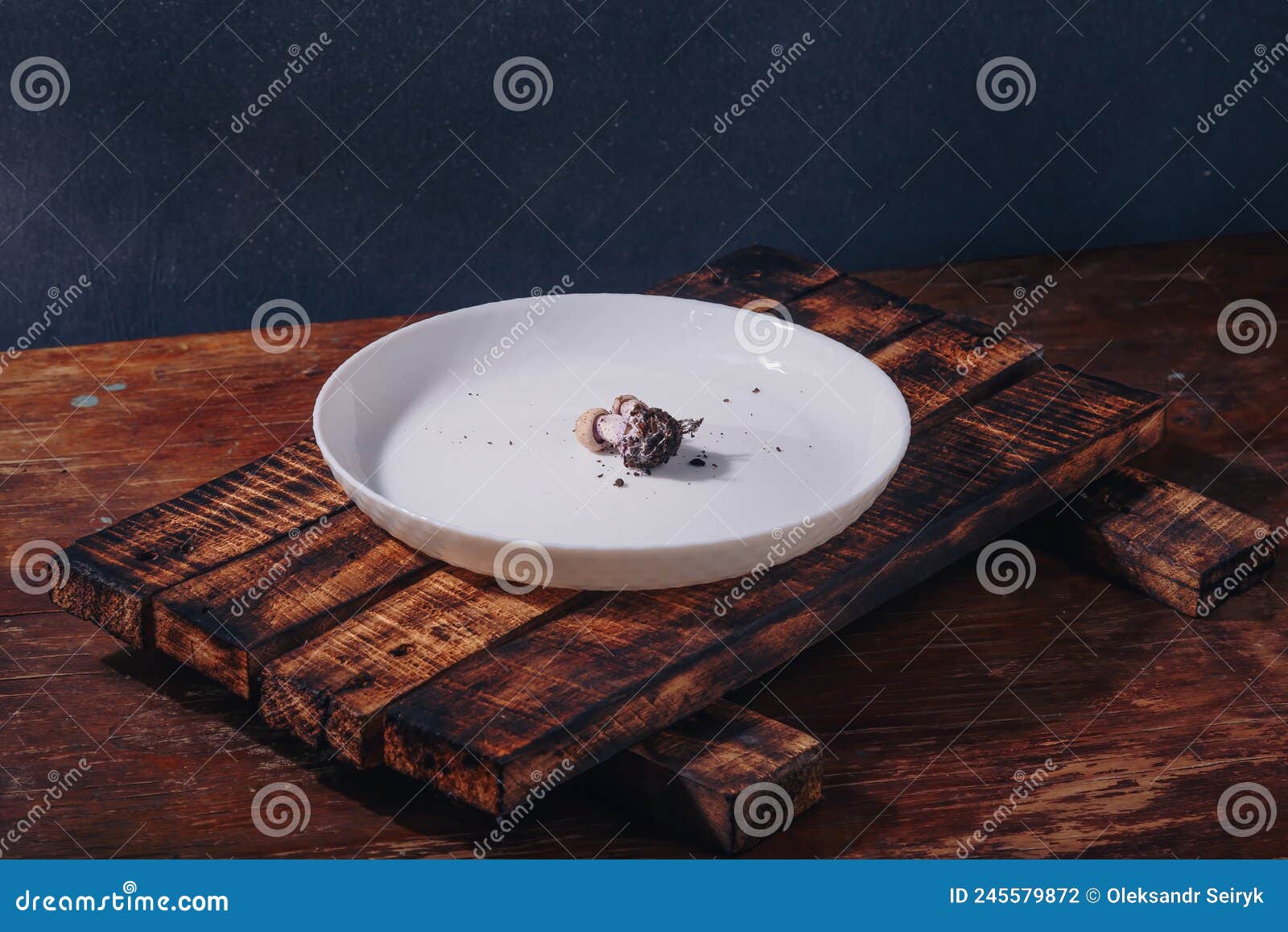 tiny mushroom with soil right on plate. humanity using earth resouces. mass consumption, lack of food, harmful effect on