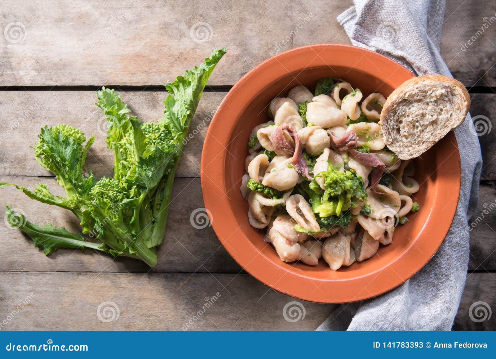 tipical dish of apulia region pasta orecchiette with turnip greens and salted anchovies, close-up, rustic style