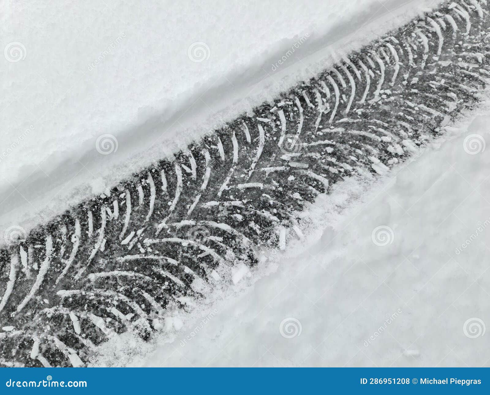 Tire Tracks on Snow Covered Streets in a Close Up View Stock Photo