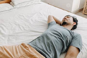 Tired Man is Lying on the Bed As he Out of Energy. Stock Photo - Image ...