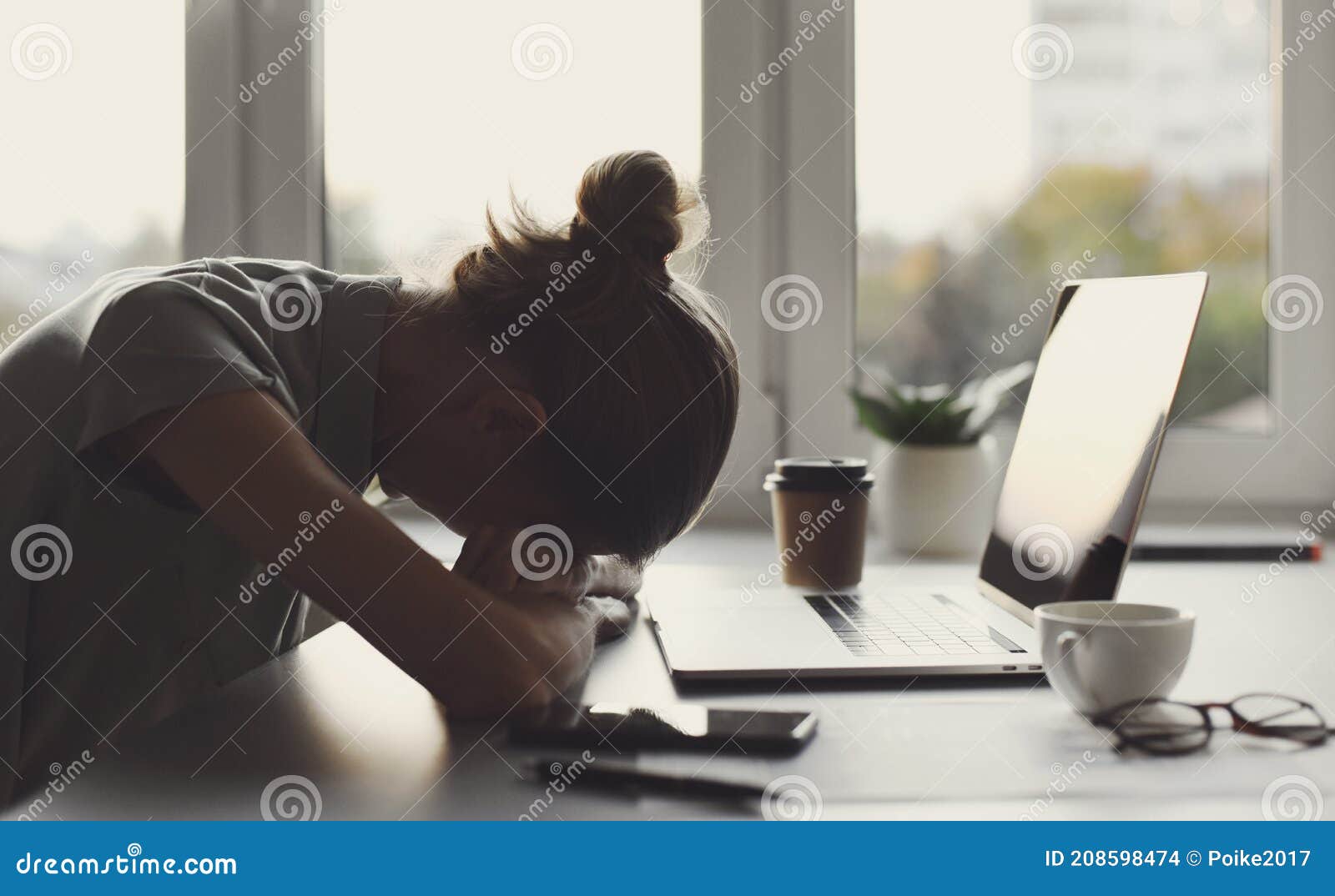 tired business woman sleeping on table in office. young overworked exhausted girl working from home.