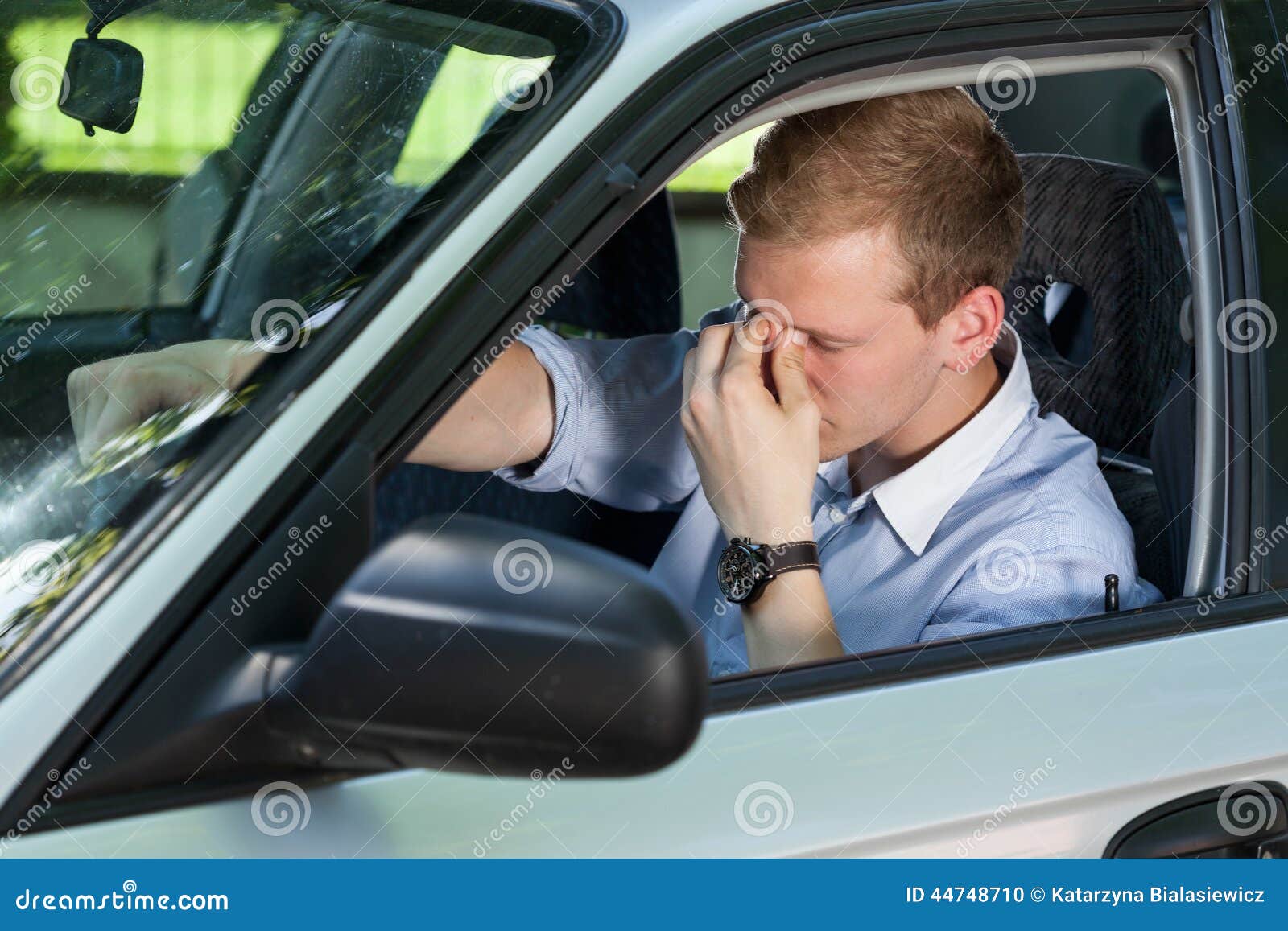 tired businessman driving a car