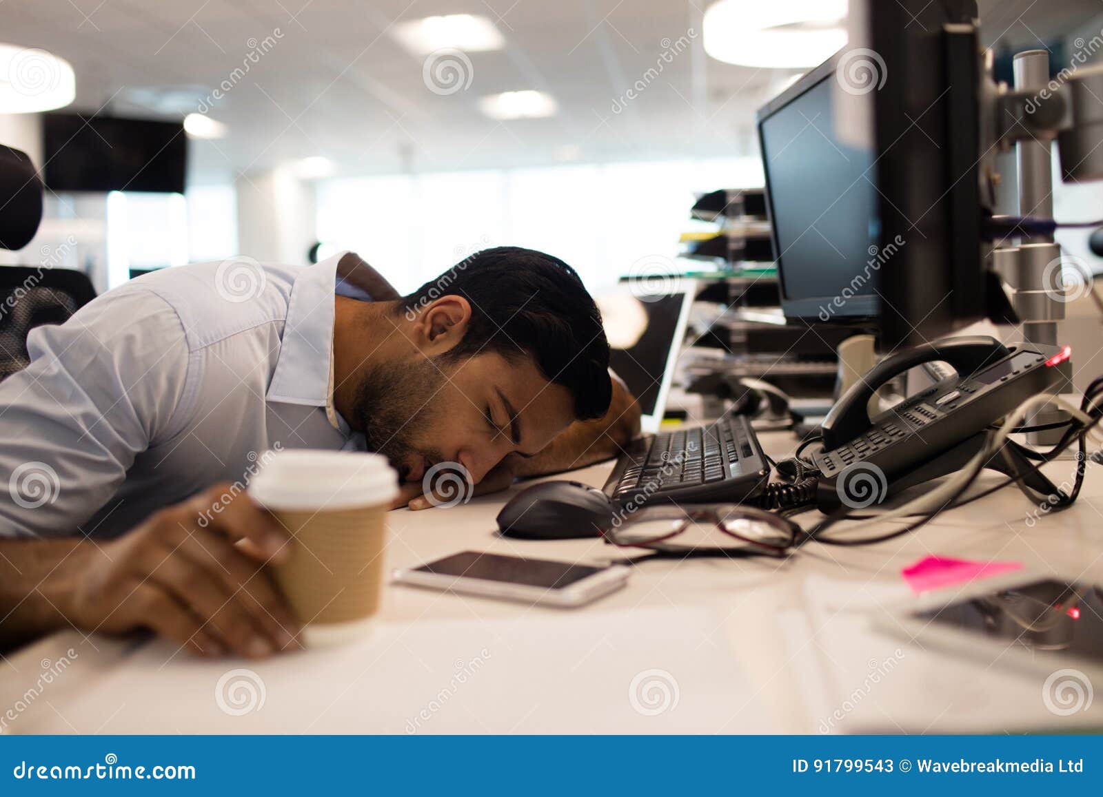 Tired Businessman Sleeping By Desktop Computers At Office Stock