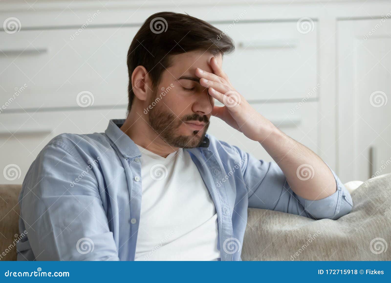 tired caucasian man suffer from headache at home