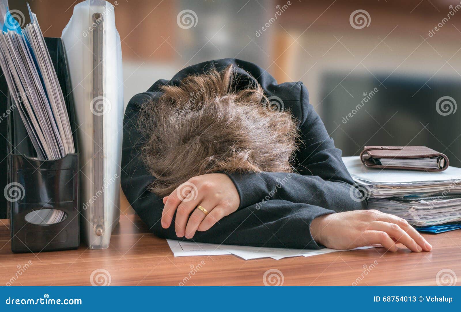 Tired And Exhausted Workaholic Woman Sleeping On Desk In Office