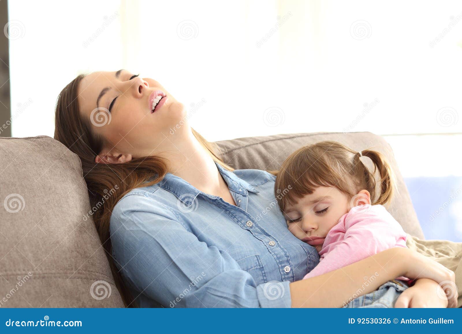 tired mother sleeping with her baby daughter