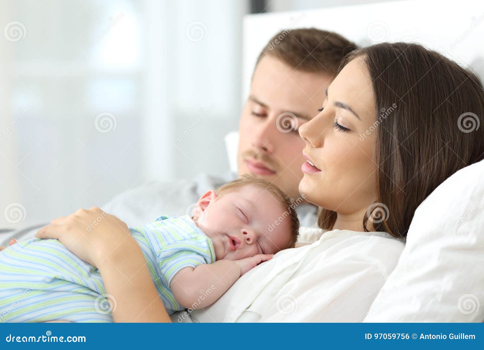 tired parents sleeping with their baby
