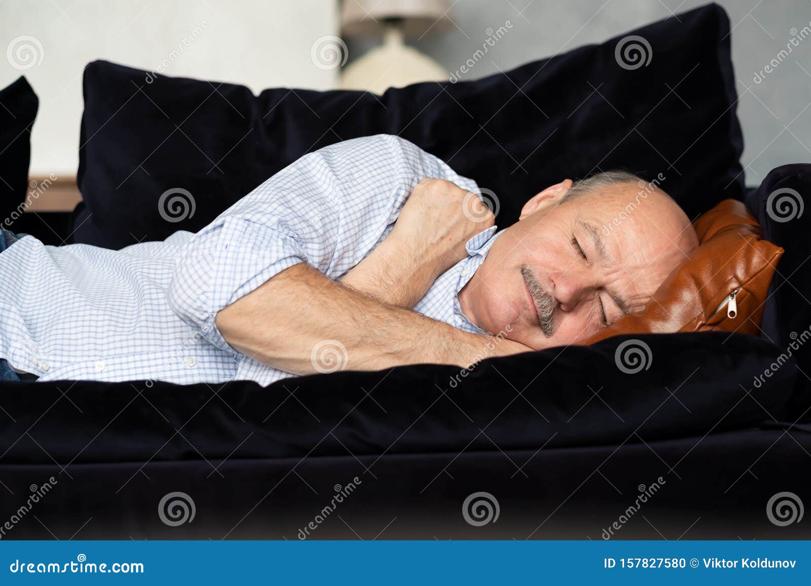 tired senior hispanic man sleeping on couch, taking afternoon nap