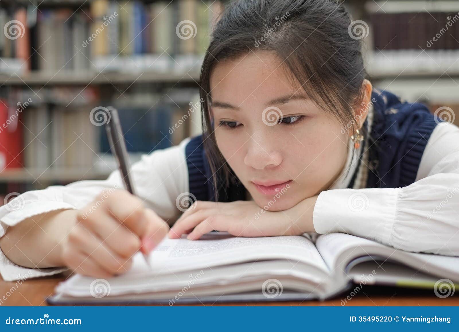 tired student doing homework in library