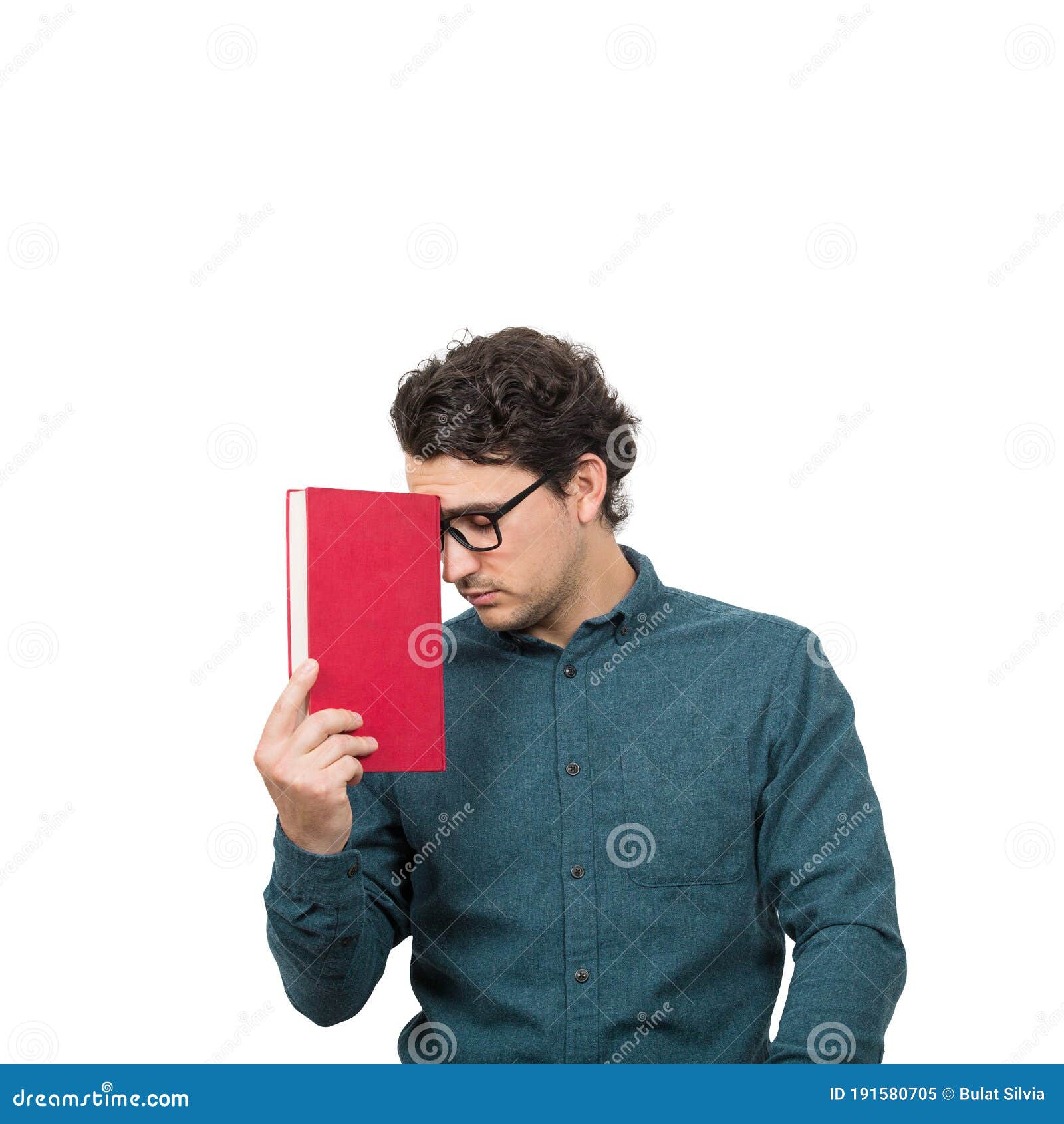tired student guy looking down with pessimistic emotion, holding a book,  on white background. confused young man has