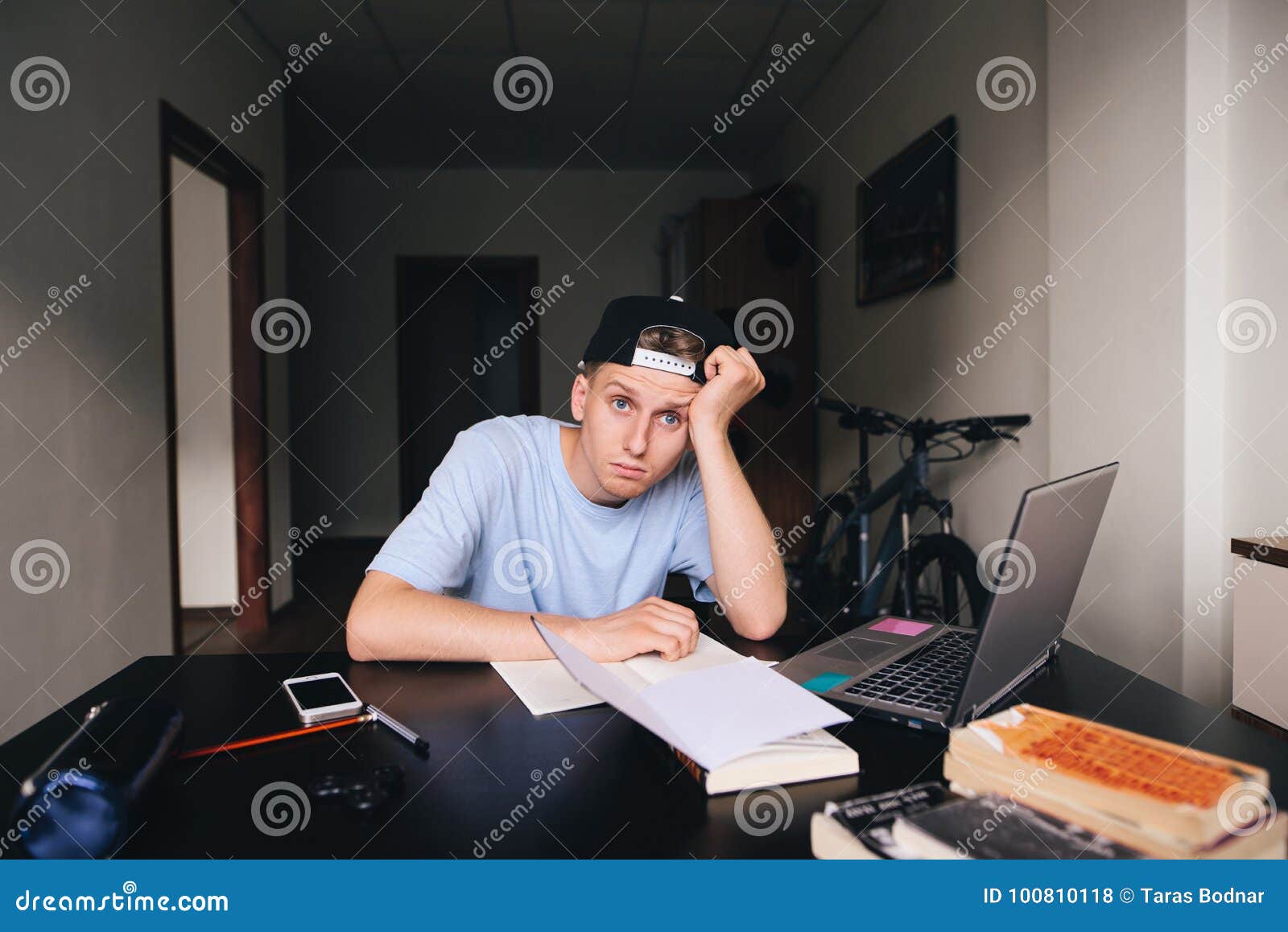 A Tired Student Sitting at His Desk in His Room. Homework. a Look at