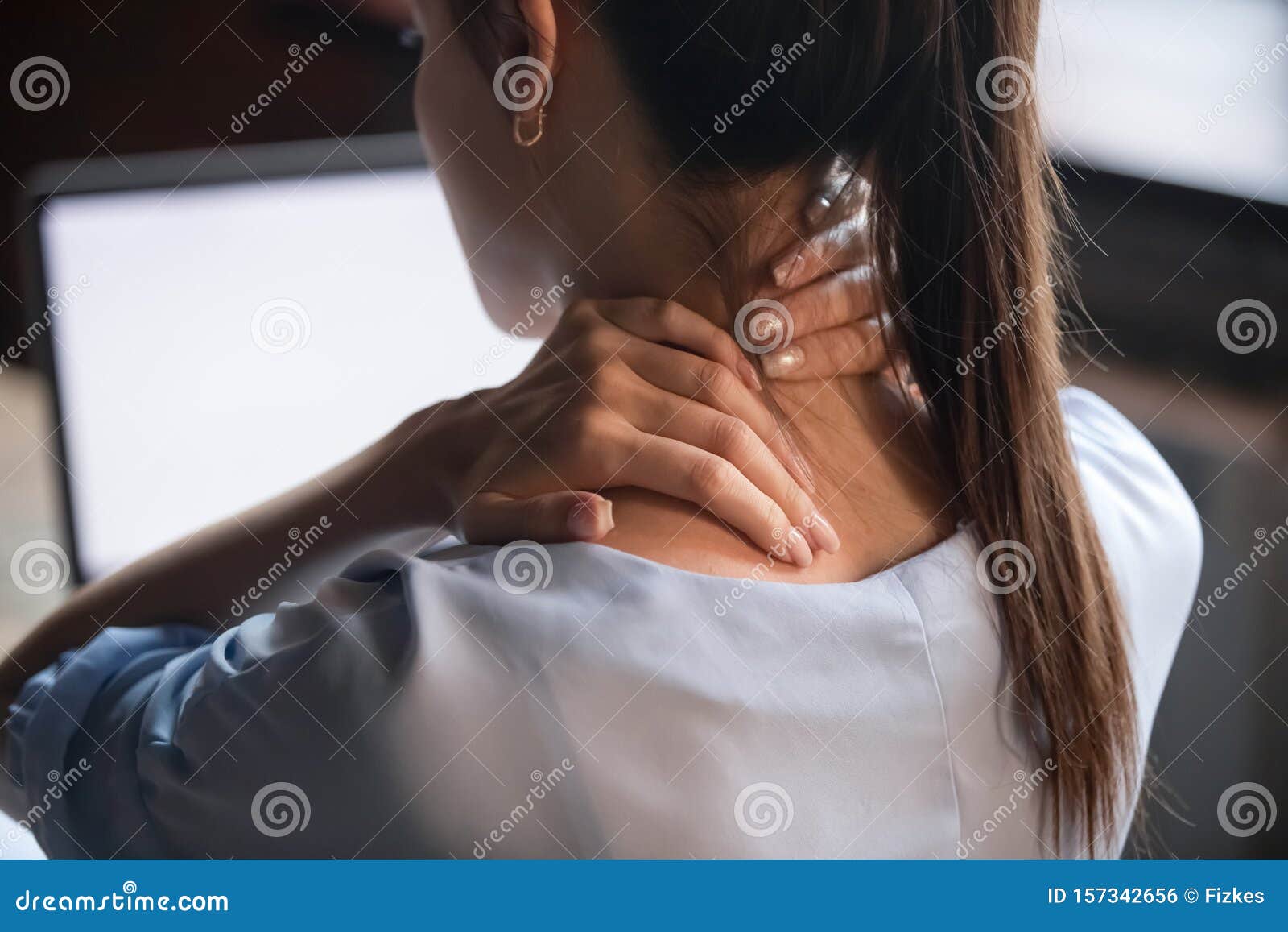 tired woman rubbing stiff sore neck, close up rear view