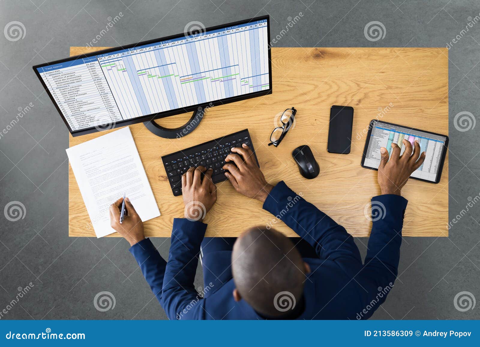 tired young african man doing multitasking work on laptop