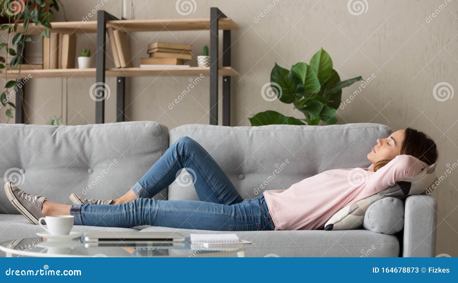 tired young woman relax at home sleeping on cozy couch