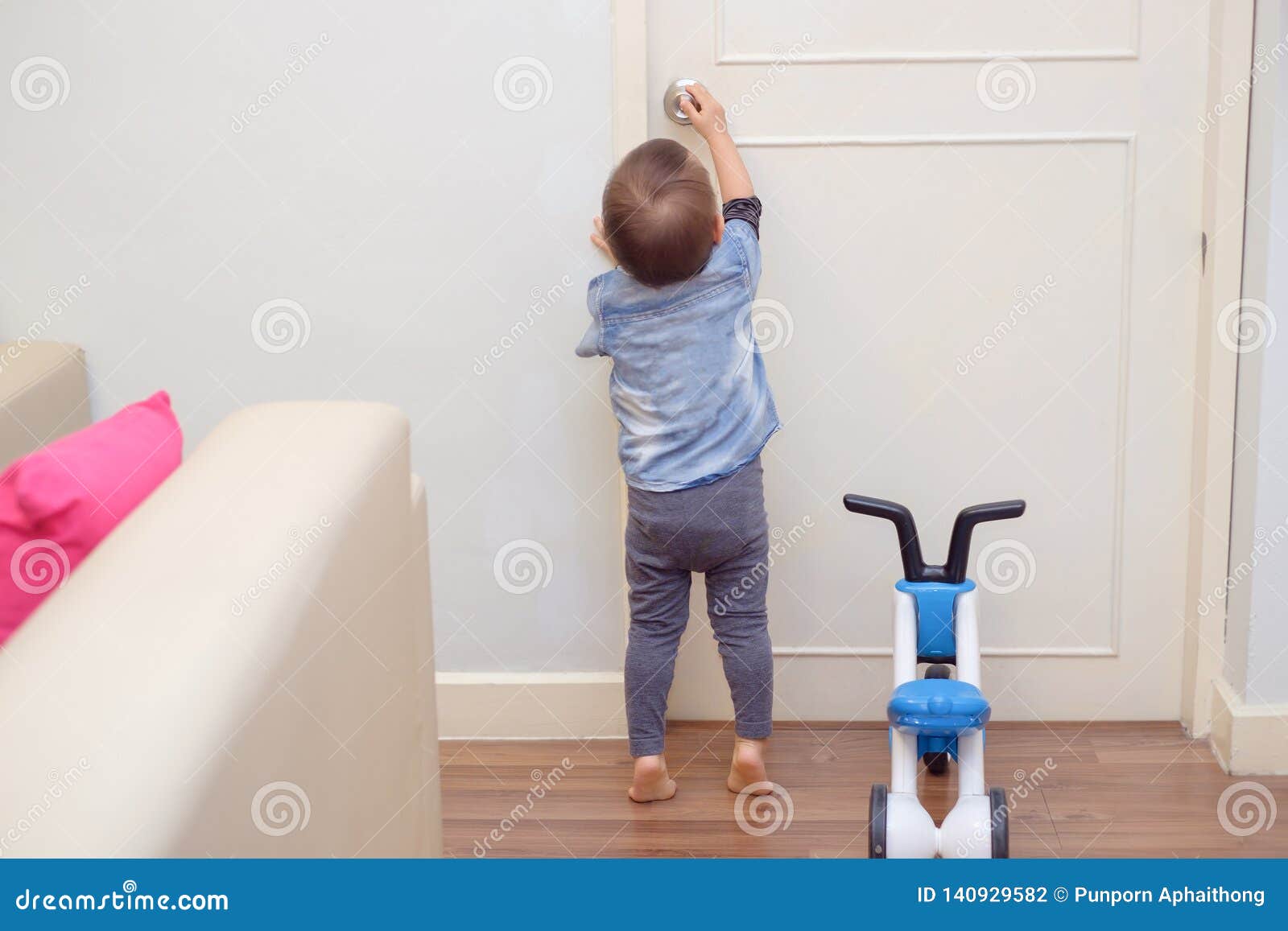 toddler baby boy standing on tiptoes at home