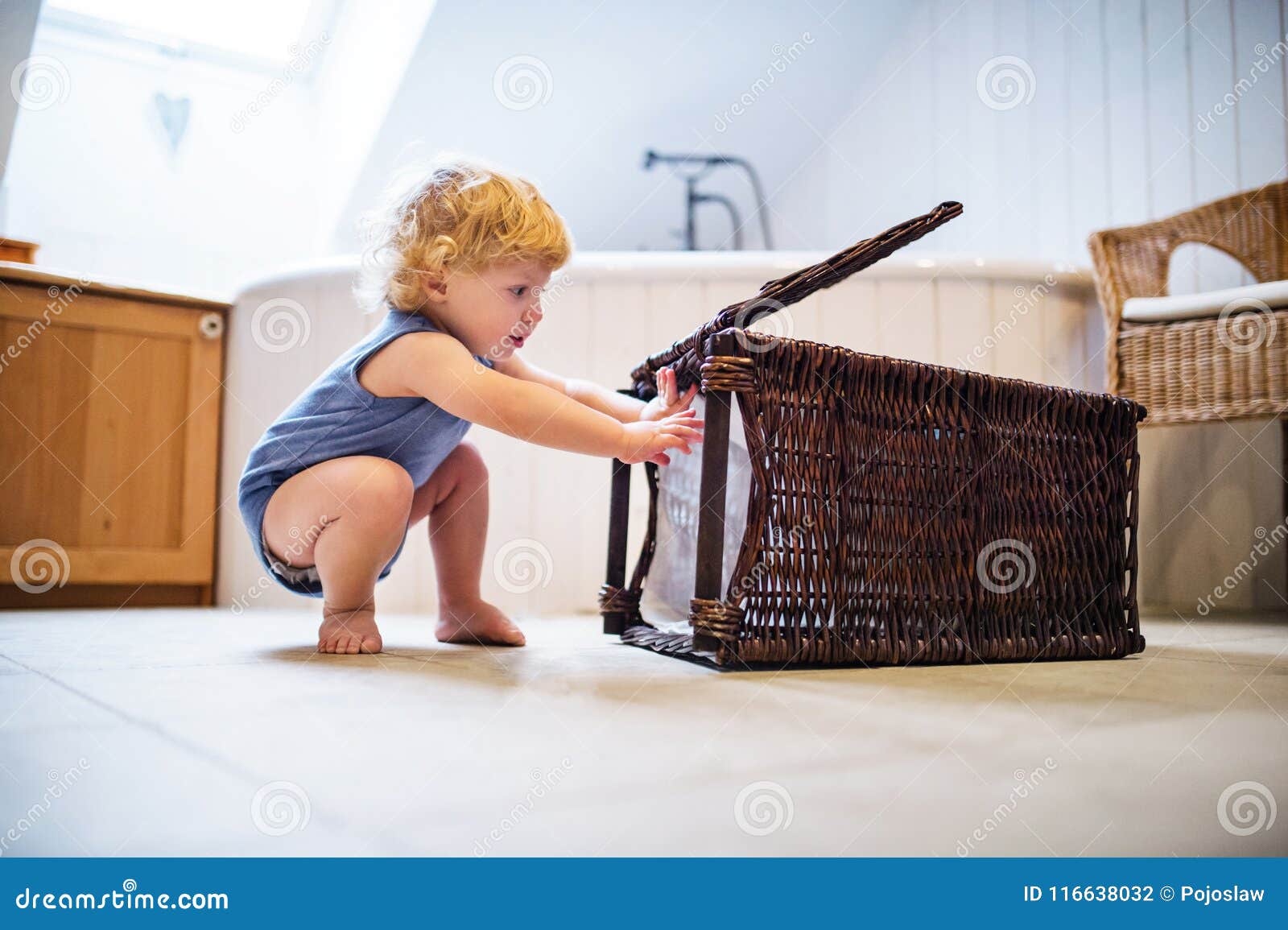 Toddler Boy with a Laundry Basket in the Bathroom. Stock Photo Image