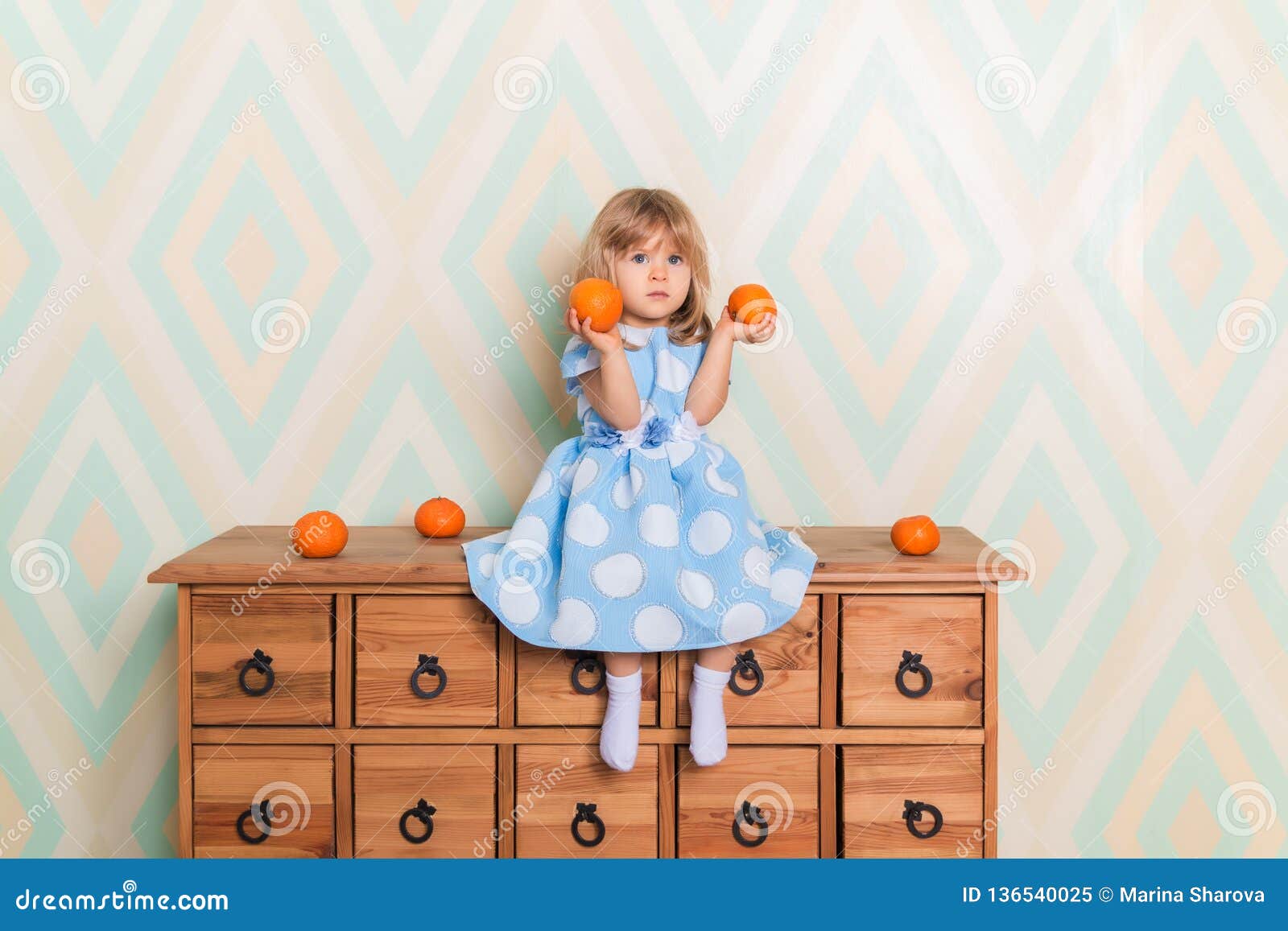 Toddler Child Baby Girl In Light Blue Dress Seriously Sitting On