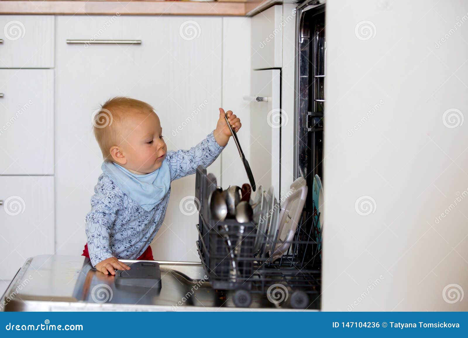 Toddler Child Boy Helping Mom Putting Dirty Dishes In Dishwasher At