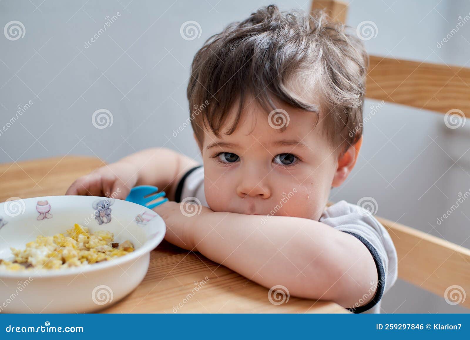 Toddler Eating Eggs for Breakfast and Fooling Around Stock Photo