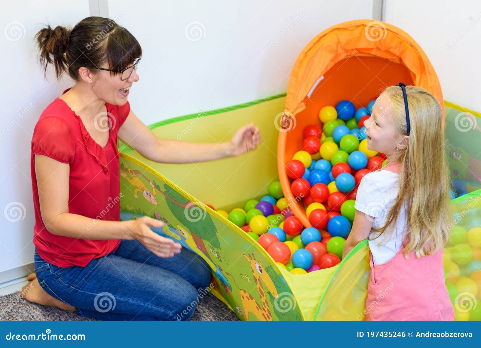 toddler girl in child occupational therapy session doing playful exercises with her therapist.