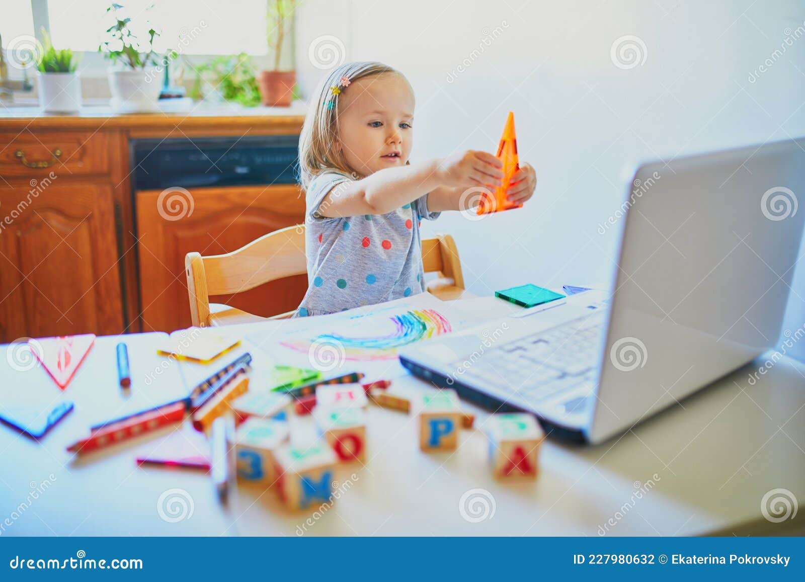 toddler girl learning s in front of laptop