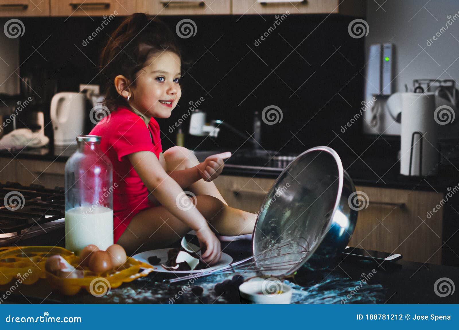 toddler girl smiling while grab chocolate in a mesy table