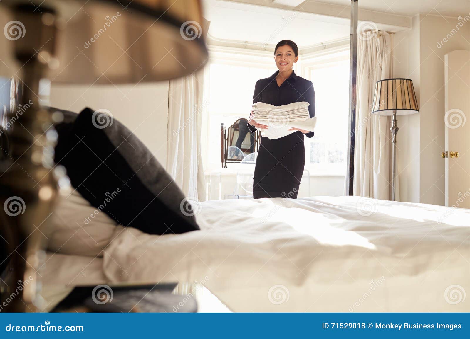Nettoyage de femme de chambre de femme dans une chambre à coucher ...