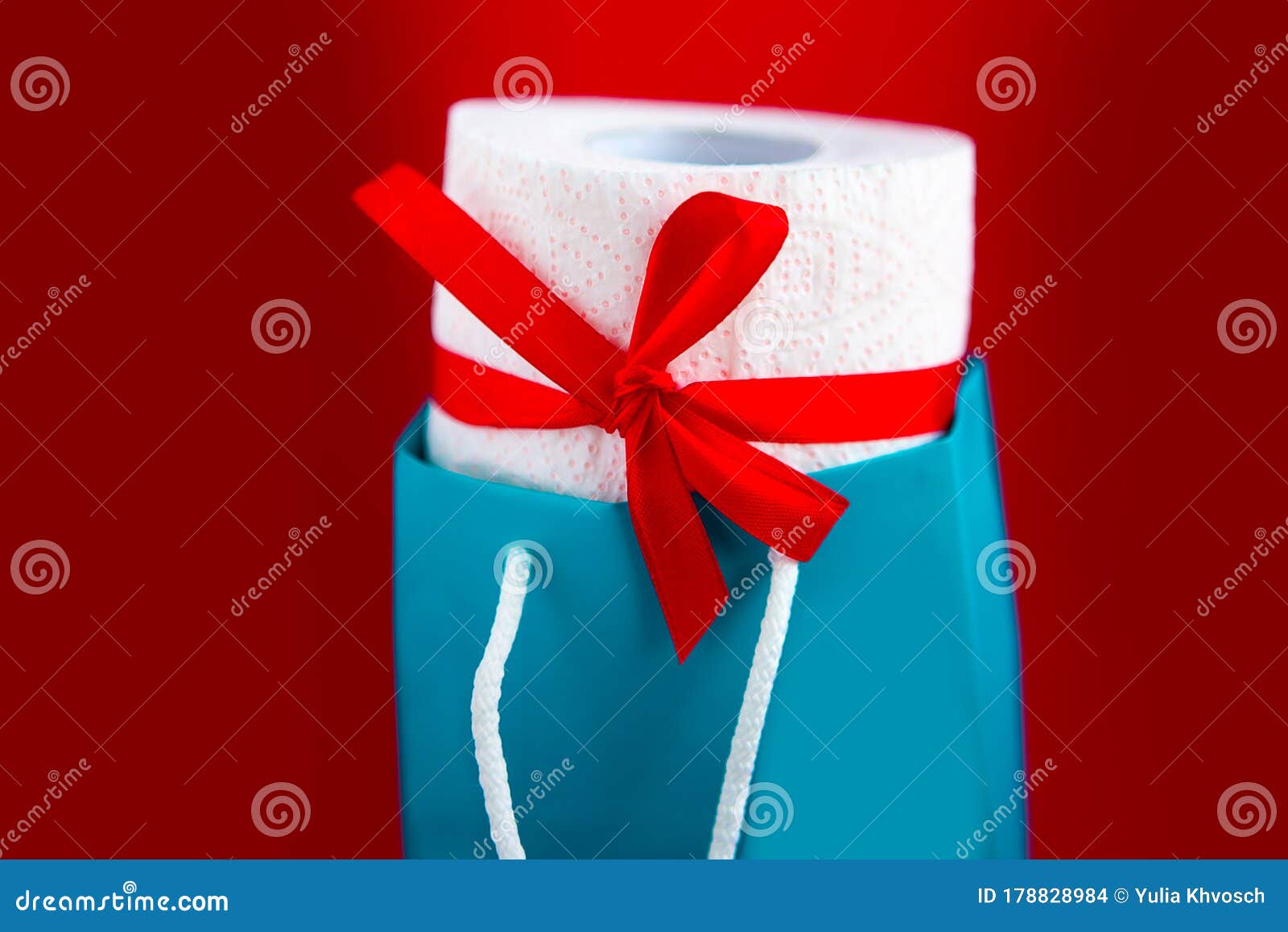 toilet paper roll in gift box on red background. concept.