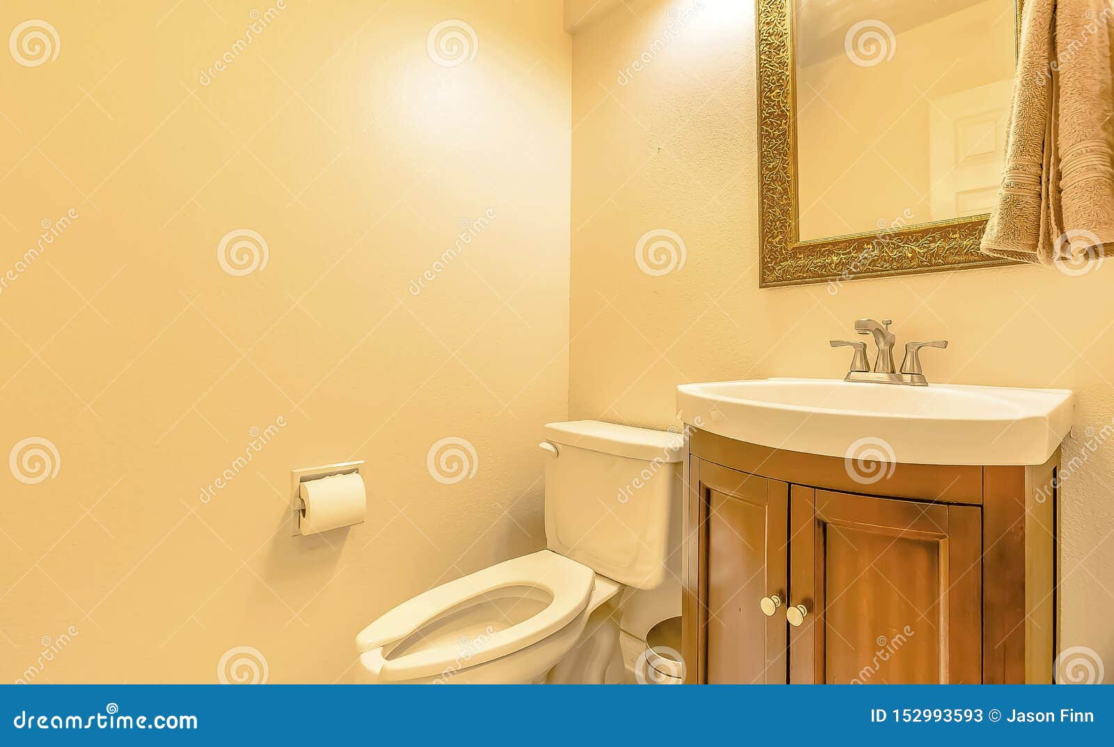 Toilet And Sink Inside The Bathroom Of A House With Cream Colored