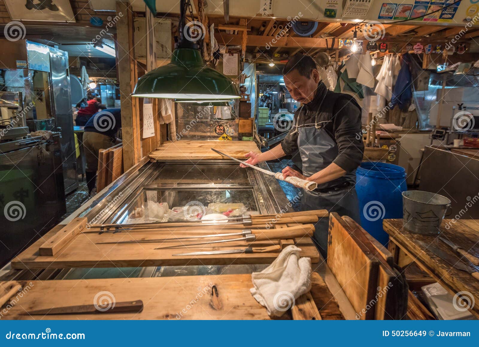 TOKYO, GIAPPONE - 22 novembre, 2014: Uomo giapponese anziano con il coltello. TOKYO, GIAPPONE - 22 novembre, 2014: Uomo giapponese anziano con i coltelli tradizionali a Tsukiji, al più grande pesce ed al mercato dei frutti di mare del mondo