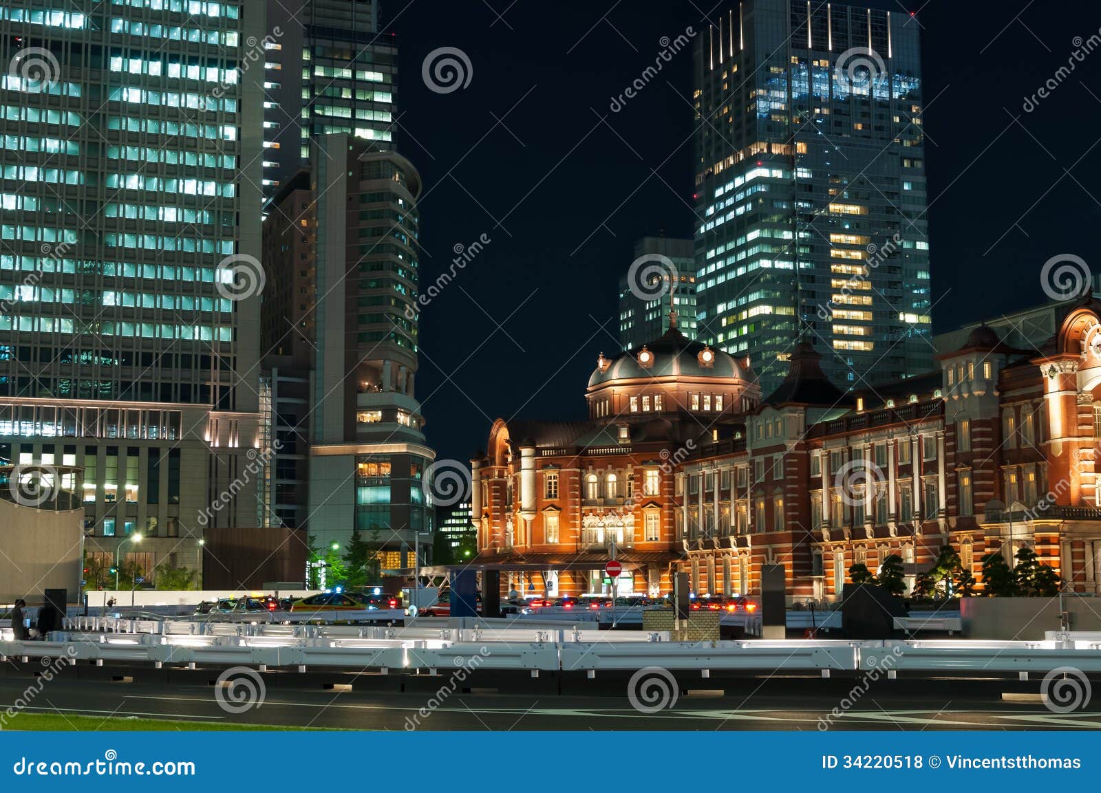 Tokyo Station at night, with the blurred motion of pedestrians and traffic.