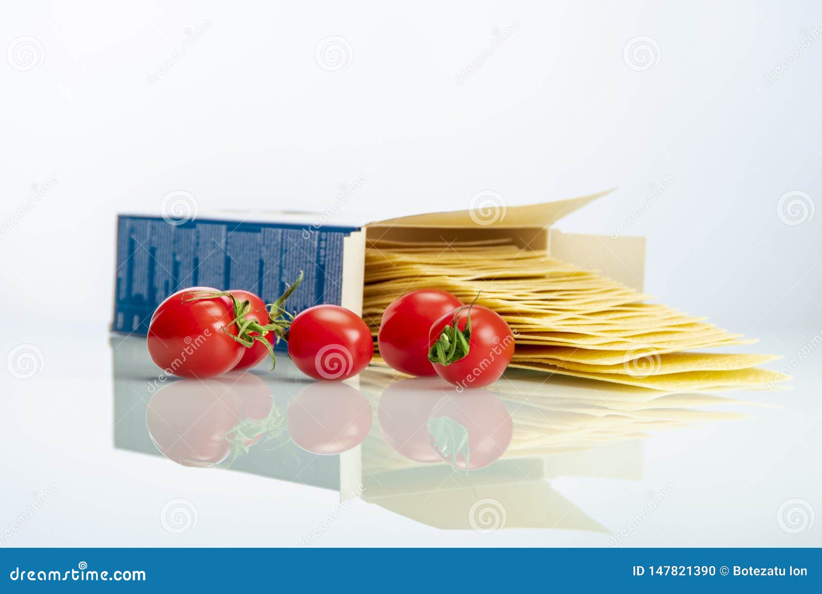 tomatoes with lasagna on white reflexive glass