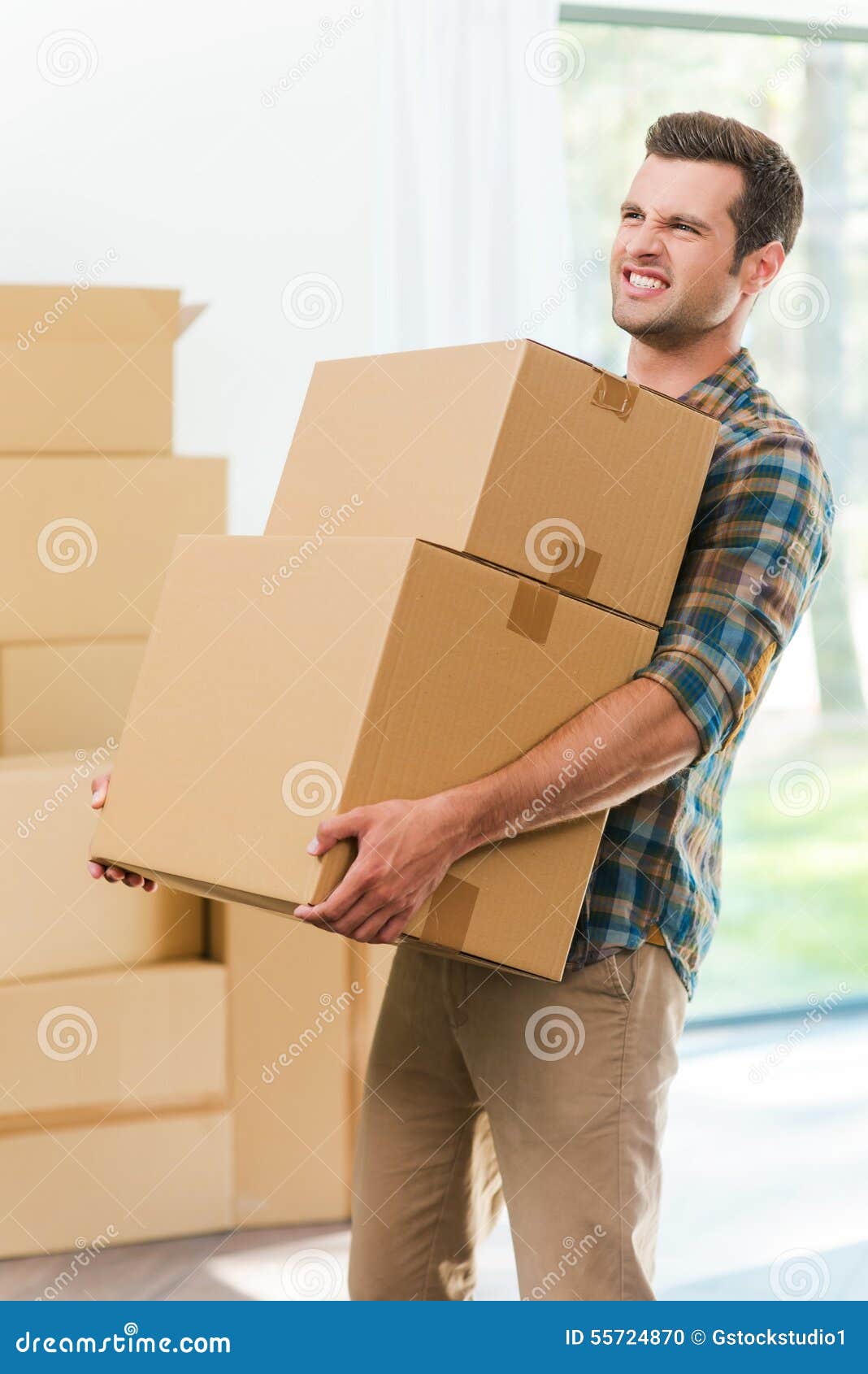 Человек держит тяжелый груз. Человек несет коробку. Тащит коробки. Несет тяжелые коробки. Человек несет тяжелый груз.