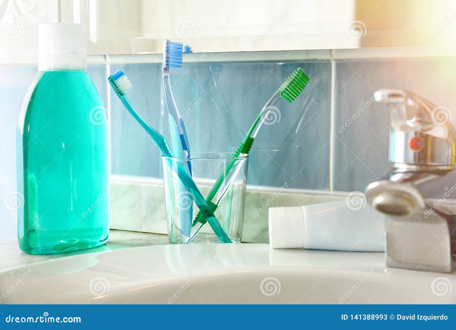 Toothbrushes Toothpaste and Mouthwash on a Sink General View Stock