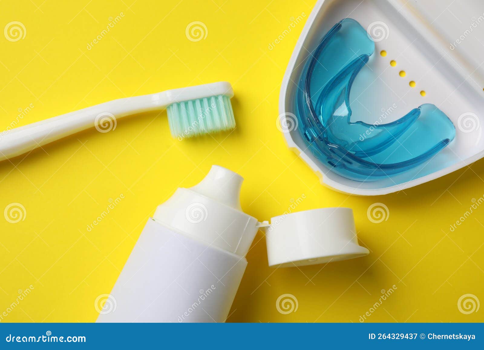 Toothpaste, Brush and Dental Mouth Guard on Yellow Background, Flat Lay