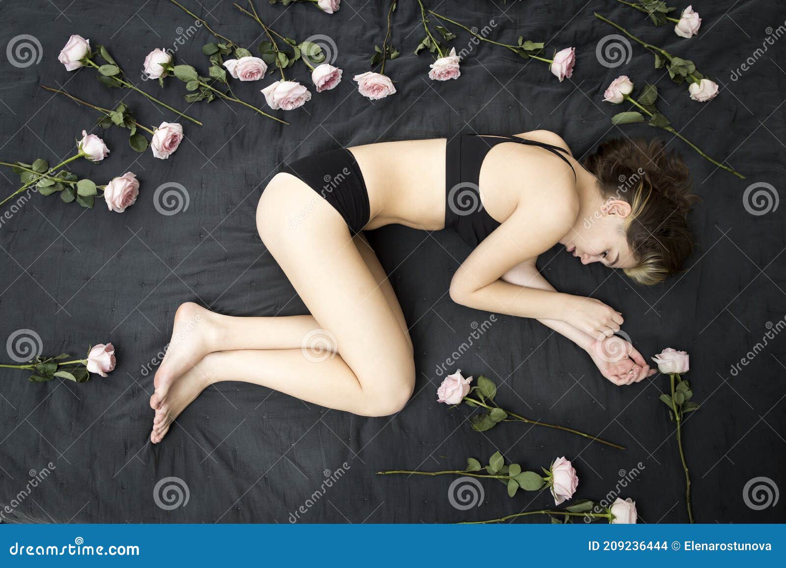 top above view stressed middle aged woman lying on bed in fetal position, embracing knees, suffering from depression or insomnia