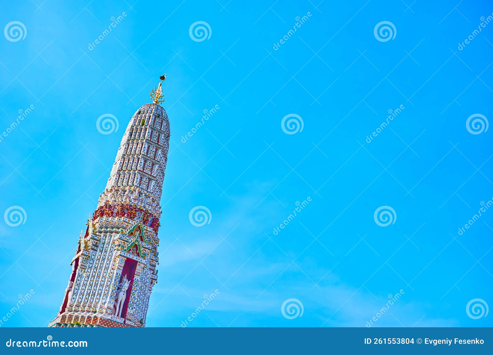 The upper part of white corner prang of Wat Arun complex with colorful porcelain decorations, Bangkok, Thailand