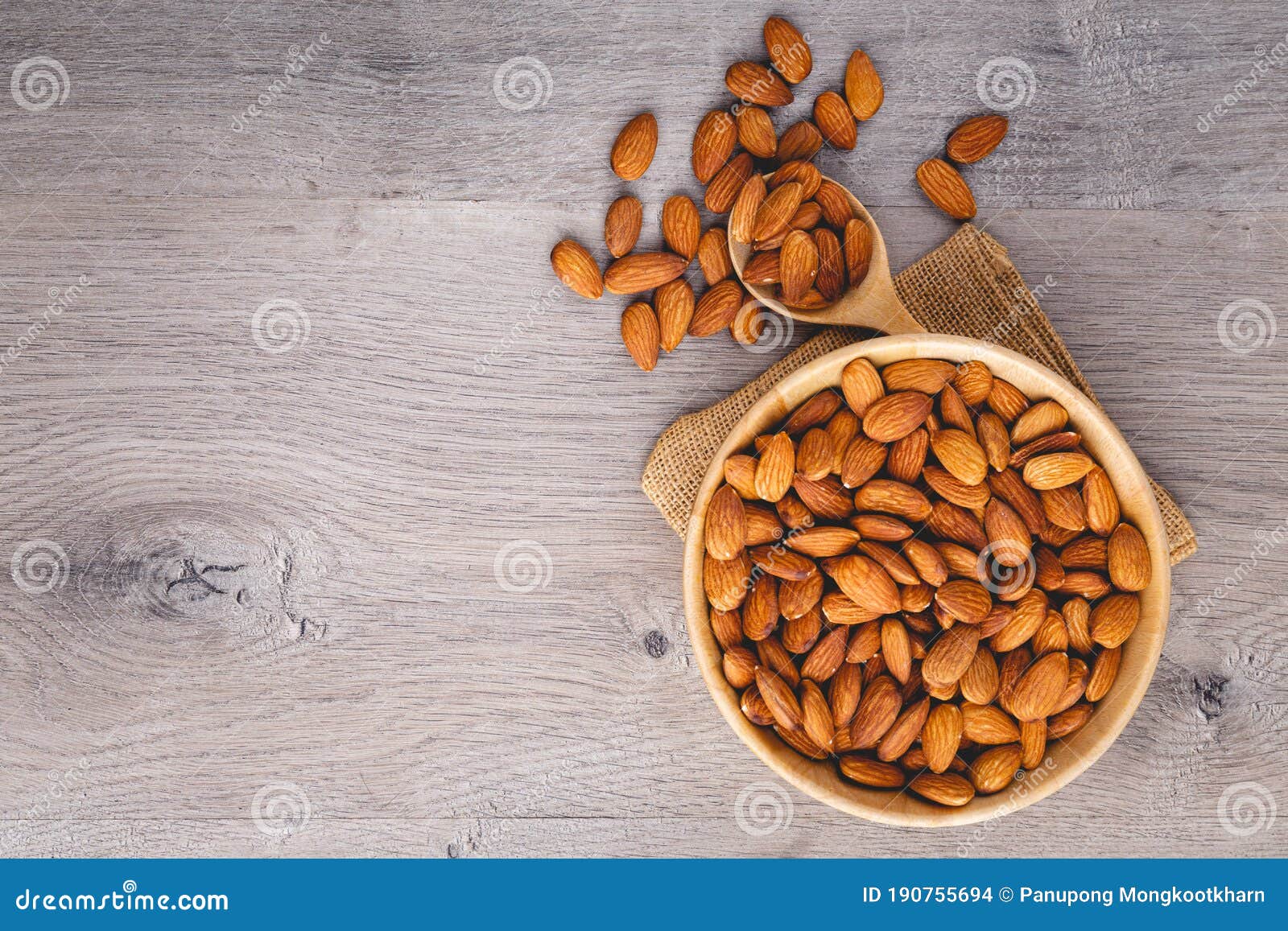 top view of almonds on wooden table with wood spoon or scoop