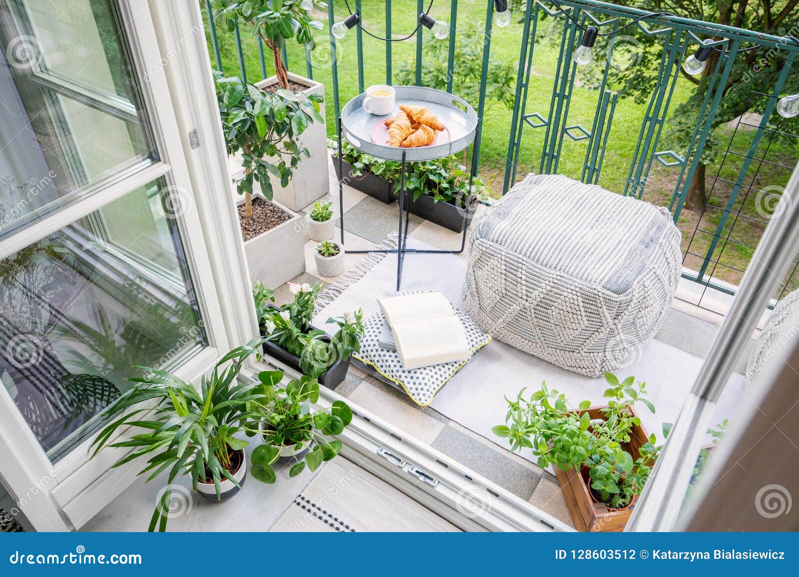 balcony with plants, pouf a table with breakfast