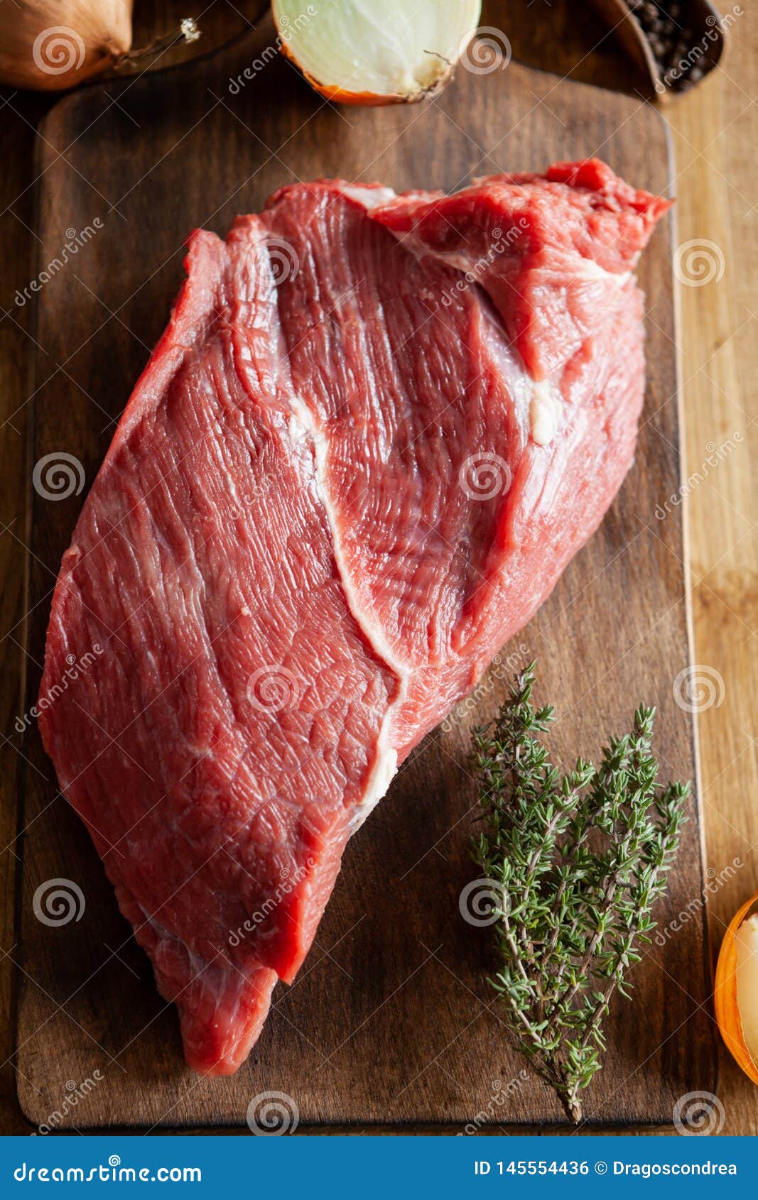 top view of beefstake seasoned with rosemary on cutting board