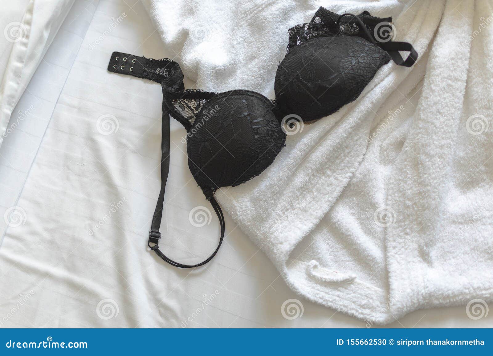 Top View of Black Bra with Hotel Bath Rope on the White Hotel Bed