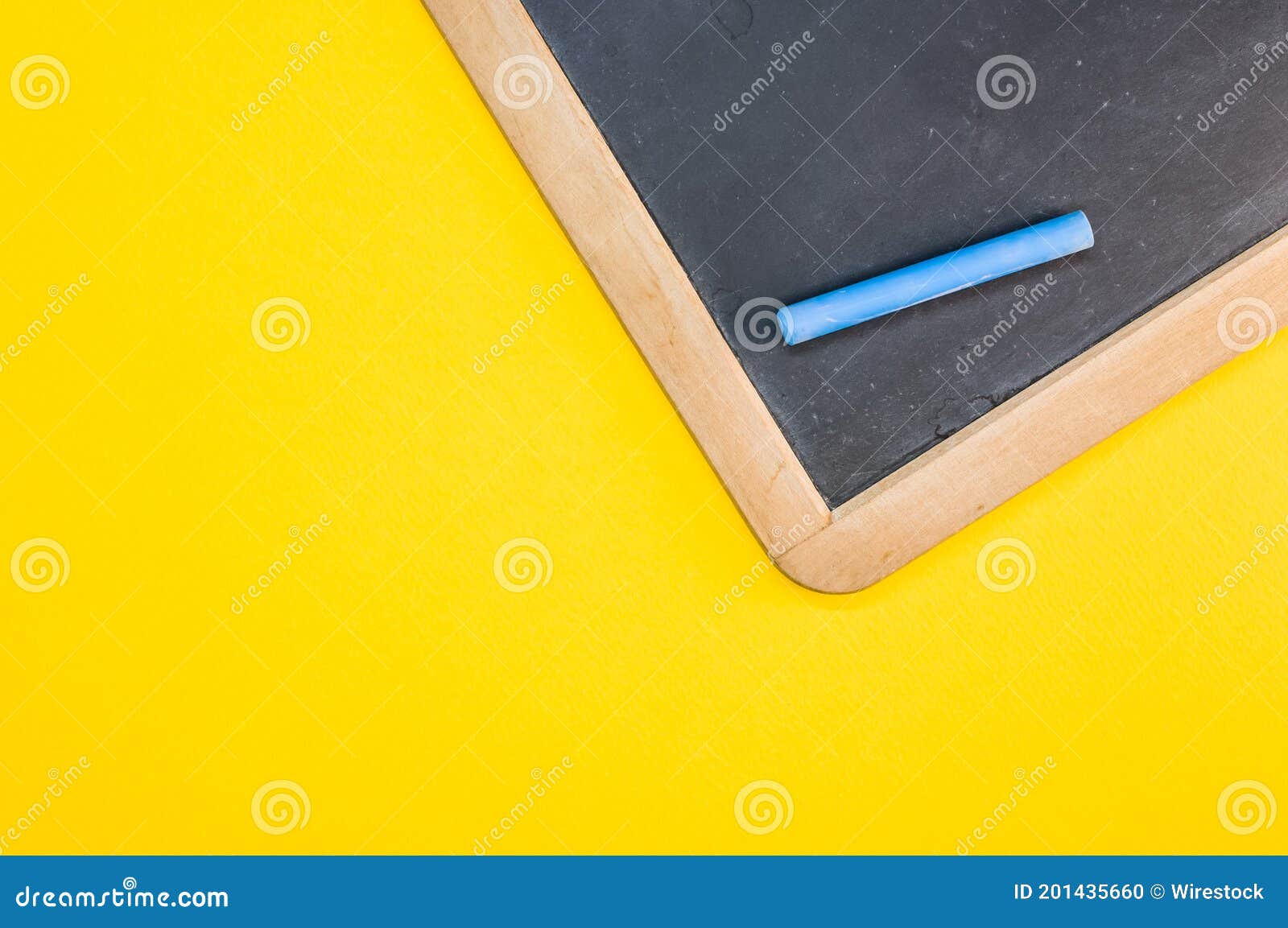 Top View of the Blackboard with Chalk on the Yellow Surface Stock Photo