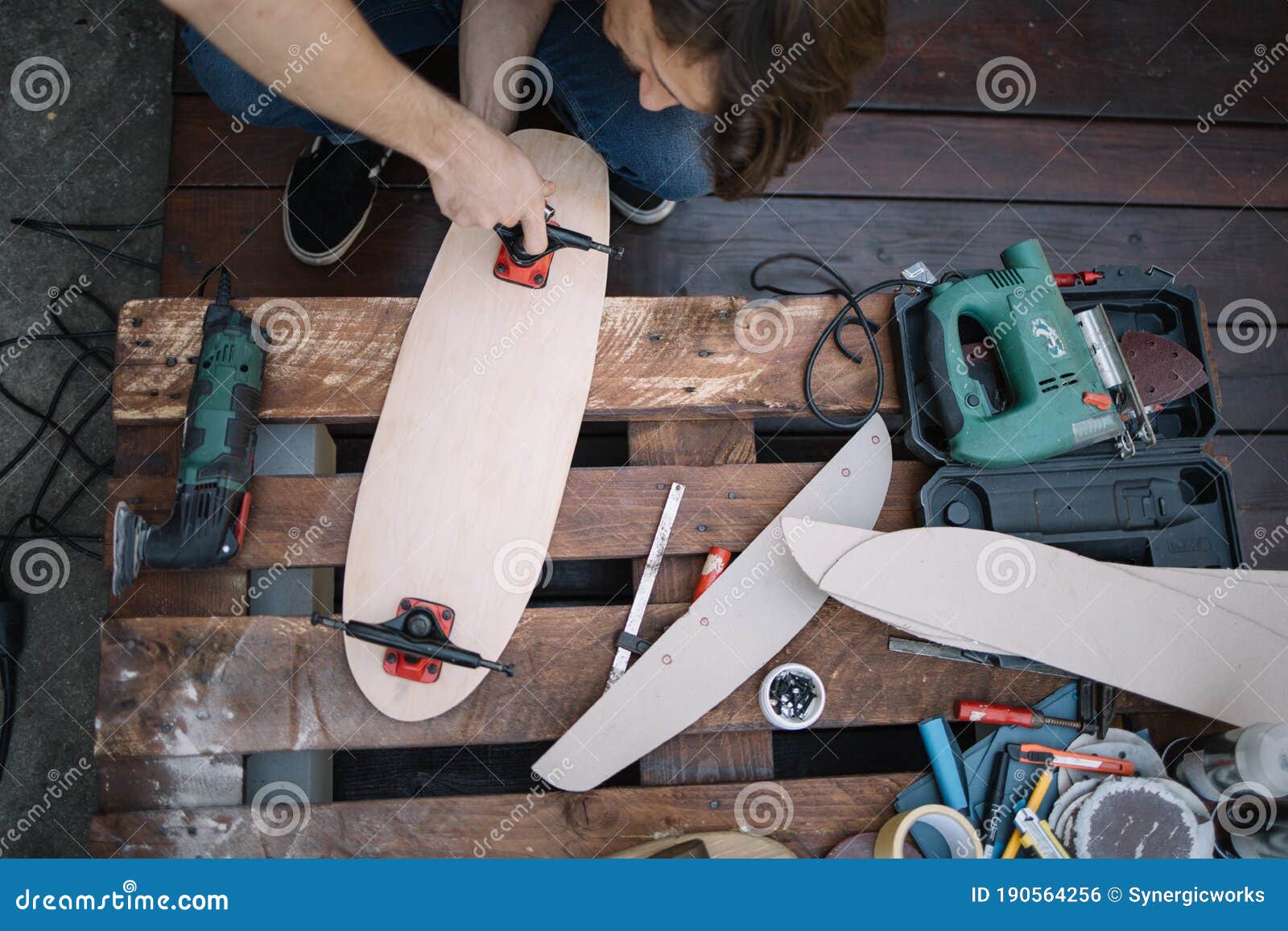 Top View of Man Assembling Skateboard Parts Stock Photo
